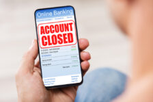 Mobile phone displaying "Account Closed" text over bank account.