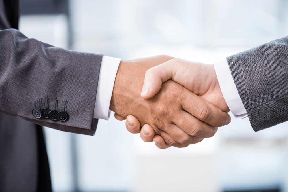 Two men shaking hands in a business deal.