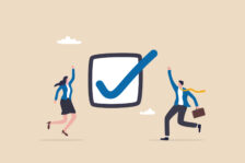 Graphic of two business people jumping for joy around a checked checkbox