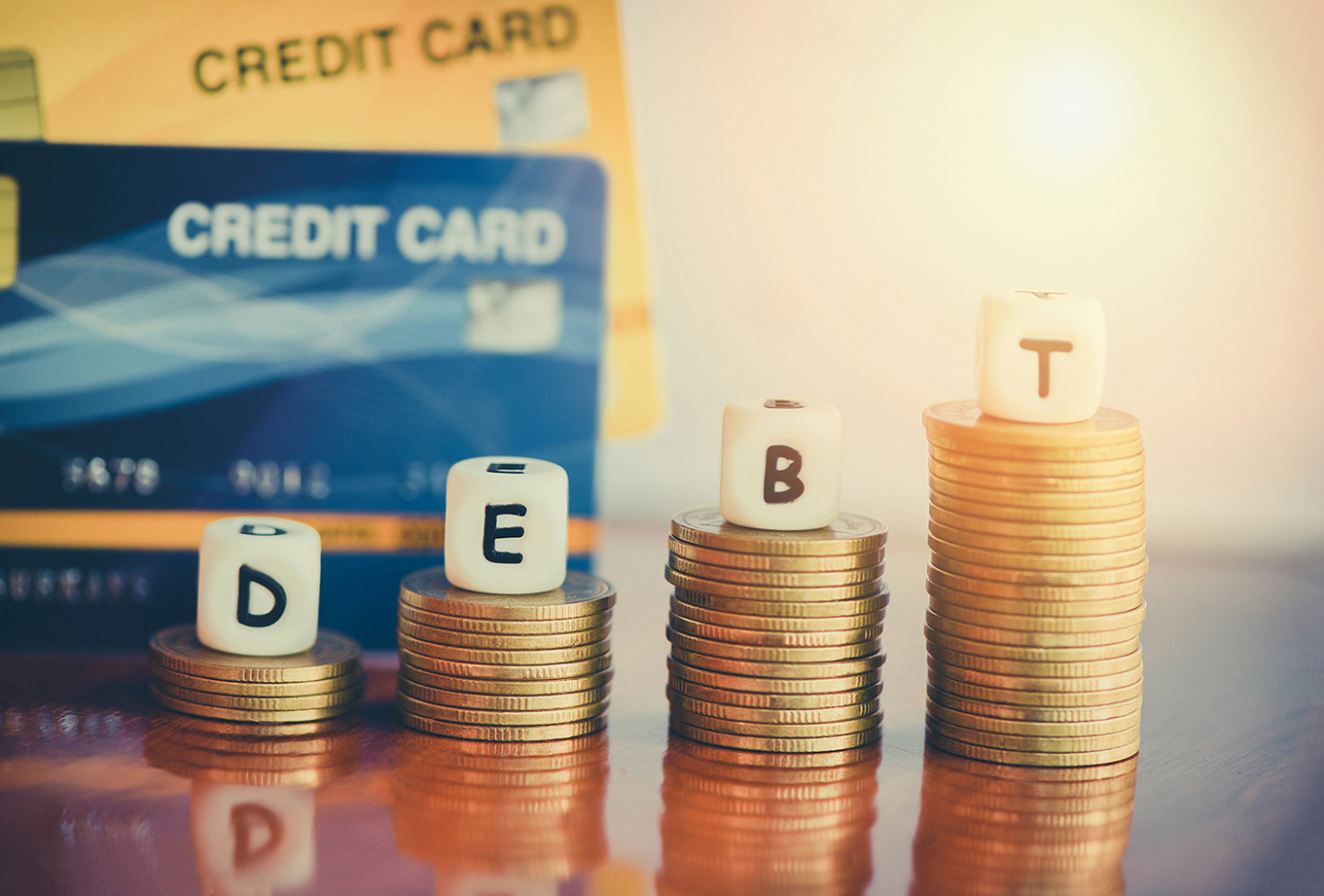 Debt credit card on coin stack on the wooden table at the office / debt management concept / credit repair