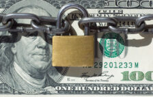 Lock and chain on top of a 100 dollar bill