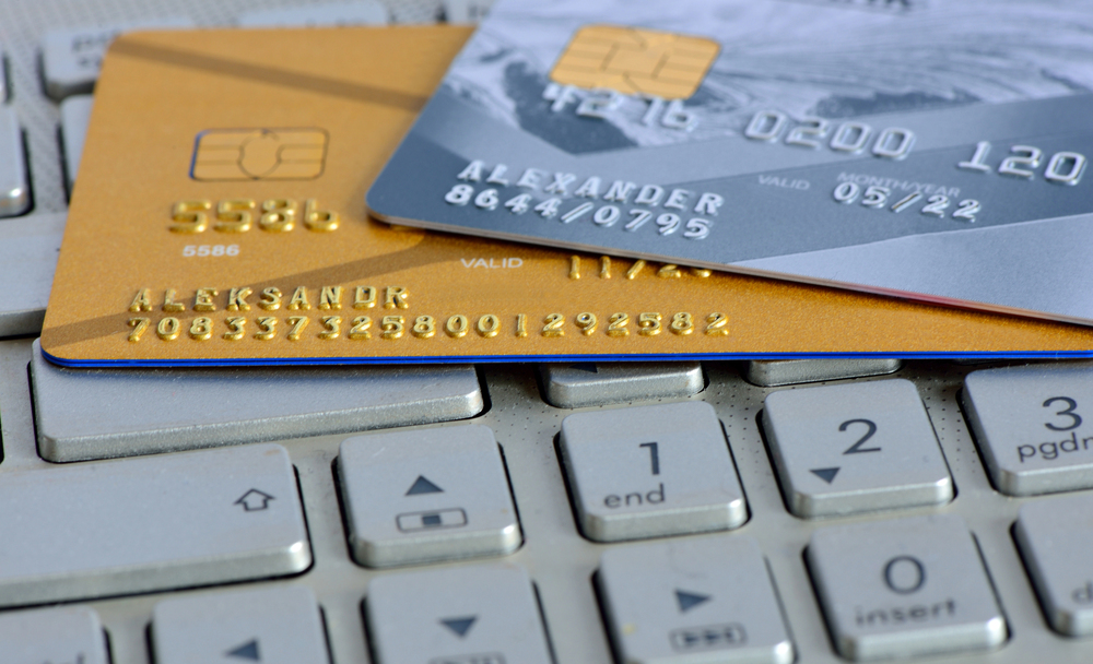 Two credit cards on top of a laptop computer keyboard.