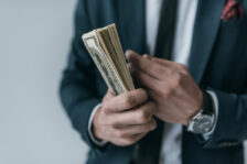 Business man holding a wad of cash