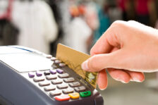 Person swiping a credit card through a card reader at checkout