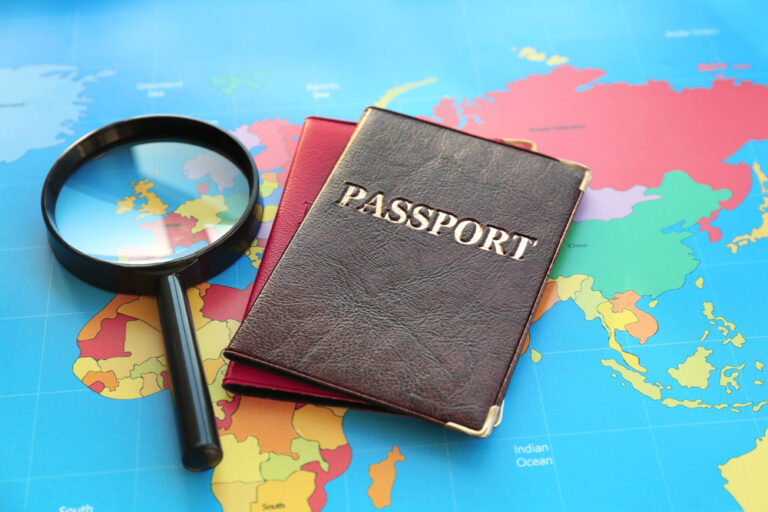 Two passport books and a magnifying glass on top of a world map, travel, visa services