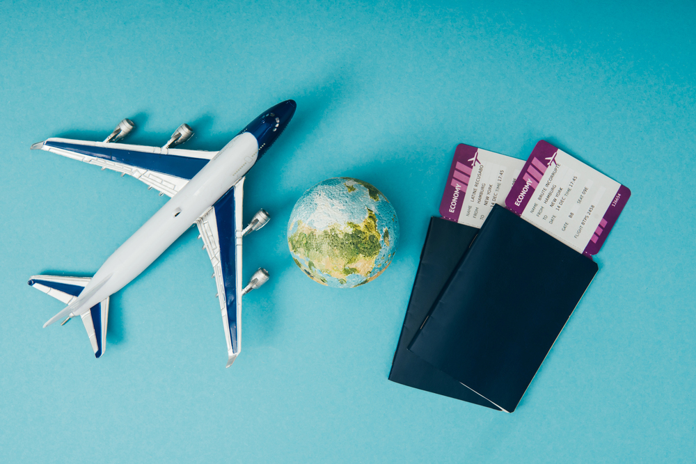 An airplane next to a small globe of Earth and two passports