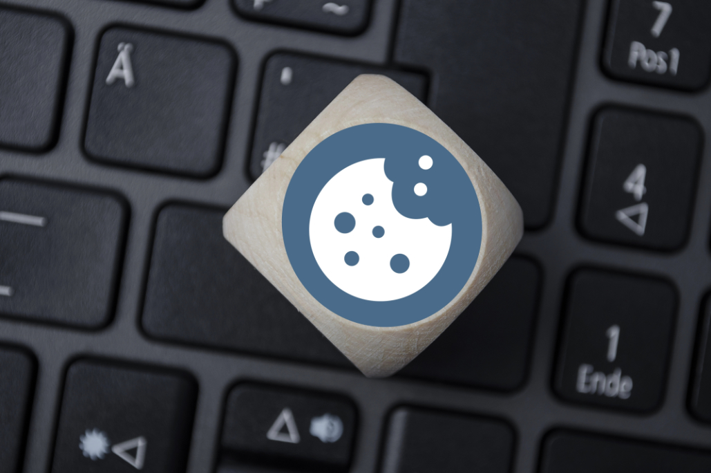 partially eaten cookie graphic on a silver button resting on top of a laptop keyboard