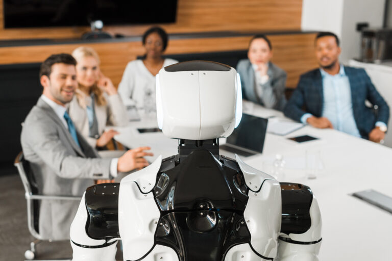 elective focus of multicultural businesspeople looking at robot in conference hall