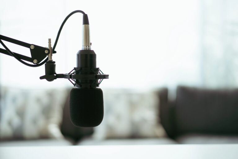 Home sound recording studio and equipment including professional condenser microphone, headphones, and laptop computer for audio mixing. Digital audio sound recording studio at home