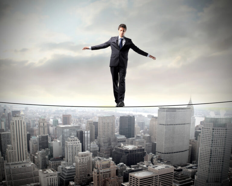 Businessperson walking on a tightrope above a city skyline