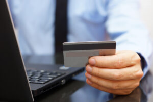 Businessman is using credit card for on line payment on laptop"